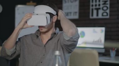 Oyun tasarımcısı VR kulaklık takıyor ve ofiste artırılmış gerçeklikte çalışıyor