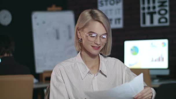 Mujer alegre de negocios que trabaja en el ordenador portátil en la oficina. Primer plano chica chequeando papel — Vídeos de Stock