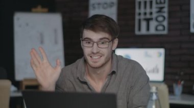 Neşeli iş adamı karanlık ofiste görüntülü sohbet ile konuşuyor..