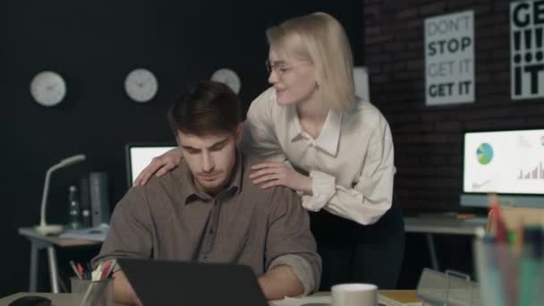 Hermosa mujer de negocios susurrando al oído joven colega en el lugar de trabajo. — Vídeo de stock