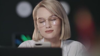 Gece ofisinde cep telefonu kullanan güzel bir iş kadını..