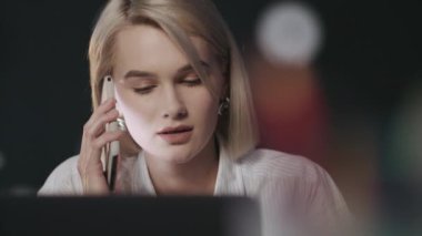 İş kadını, gece iş yerinde cep telefonunu arıyor..