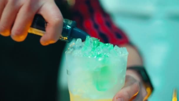 Homem preparando coquetel na taça de coquetel no bar. Preparação de bebida refrescante — Vídeo de Stock