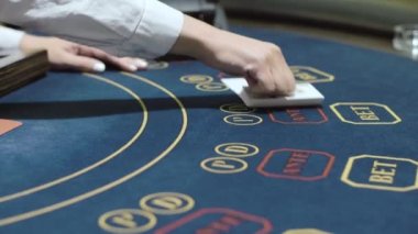 Croupier kumarhanede iskambil kağıtlarını sıraya koyuyor. Casino'da poker oynamak