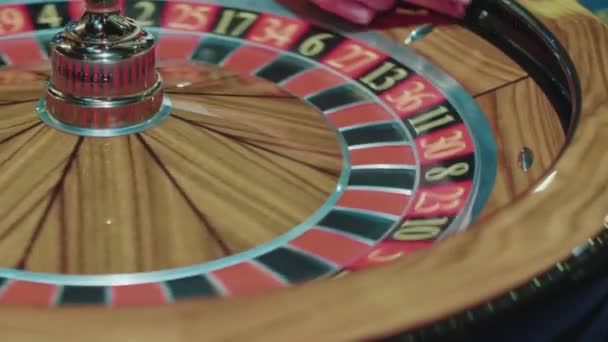 Closeup of wooden roulette wheel rotating in foreground. Table in luxury casino — Stock Video