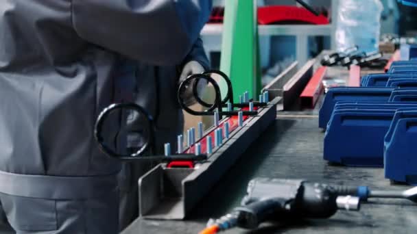 Arbetare som monterar metalldelar till enheter i verkstad för manuell montering — Stockvideo