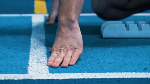 Finger des Sportlers auf Laufstrecke niedrige Startposition. Hände des Athleten — Stockvideo