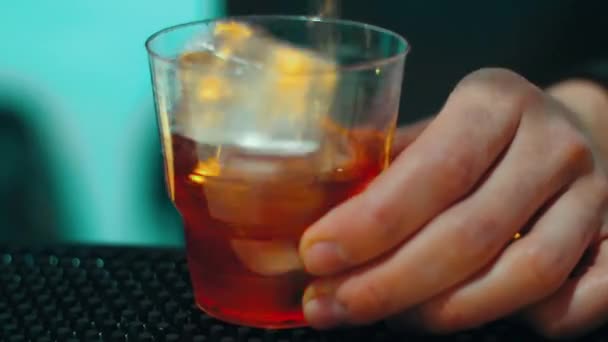 Bartender making cocktail with alcohol drink with ice in glass at bar — Stock Video