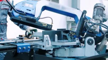 İşçi işletim kesmek testere kesme makinesi. Endüstriyel makine operatörü