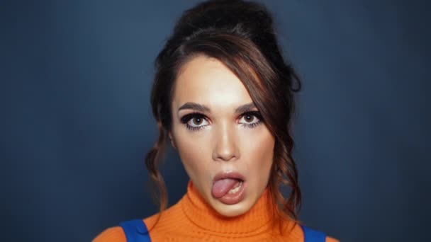 Ung kvinna med vackert utseende visar tungan. Flicka som visar grimaser — Stockvideo