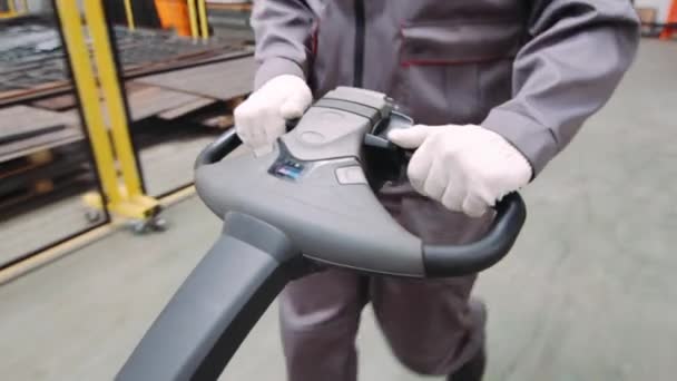 Warehouse workers hands drive hand pallet truck close up — Stock Video