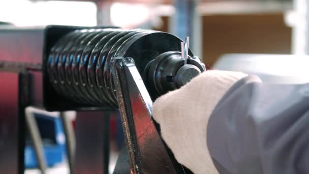 Рабочий забивает штифт в металлическую деталь во время ручной сборки — стоковое видео