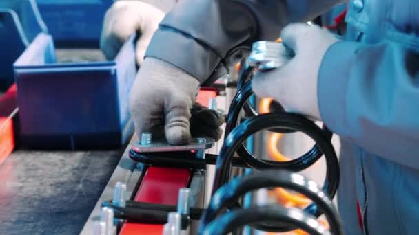 Trabajador de fábrica poniendo almohadillas de metal en el perno. Trabajo manual en taller de montaje de planta — Vídeo de stock