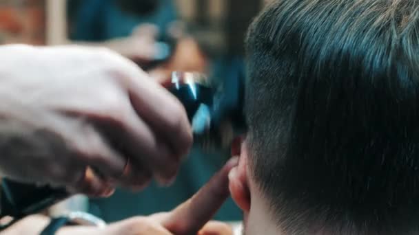 Peluquero haciendo peinado al hombre usando la máquina cortadora eléctrica en la barbería — Vídeo de stock
