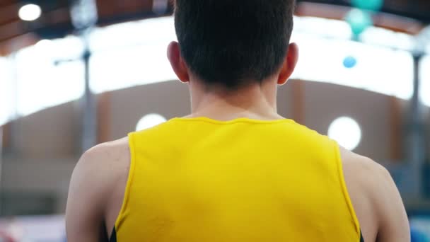 Atleta en forma amarilla preparándose para el rendimiento. Detrás del hombre en camisa deportiva — Vídeos de Stock