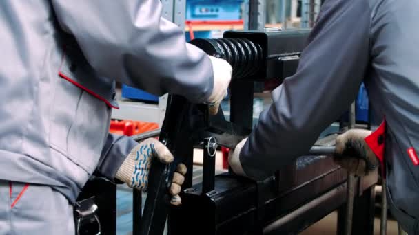Trabalhadores fixando amortecedor de mola preta na máquina para processamento — Vídeo de Stock