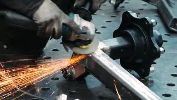 Mechanik za pomocą szlifierki metalowej do polskiej powierzchni metalicznej. Jaskrawe błyski — Wideo stockowe