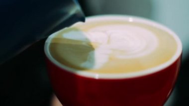 Profesyonel barista kahve fincanı içine süt dökme güzel latte desen yapma