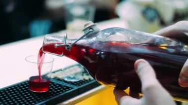 Barmen şişeden şarapları tezgahtaki bardaklara döküyor. Partiye hazırlanma