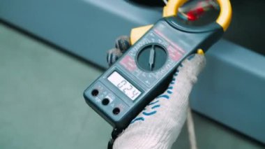 Test leyici ile endüstriyel makinenin teknik parametrelerini ölçen mühendis