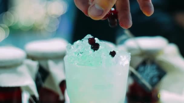 Δροσιστικό ποτό με κόκκινο φραγκοστάφυλο με πάγο σε γυαλί. Μπάρμαν κάνει κοκτέιλ βατόμουρο — Αρχείο Βίντεο