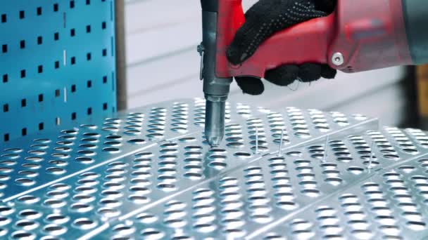 Trabalhador da fábrica instalando rebites na superfície de metal com pistola de rebite — Vídeo de Stock