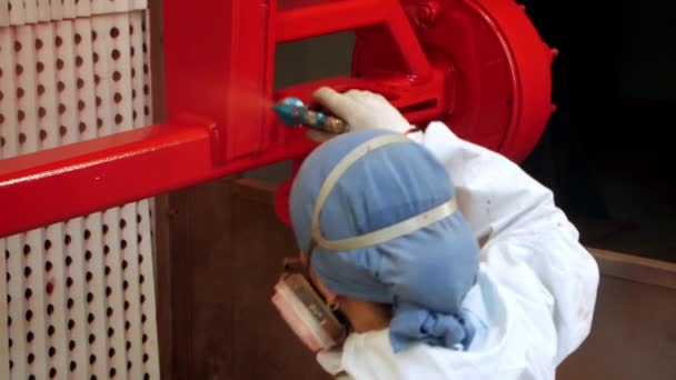 Female worker pulverizing red paint on industrial unit in workshop — Stock Video