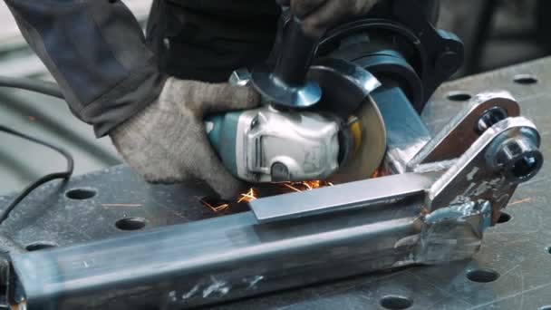 Verwerkings oppervlak voor werknemers van metalen deel met haakse slijper in werkplaats — Stockvideo