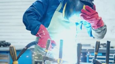 Koruyucu giysili adam ve metal boşlukları maskeleyen adam. Kasklı kaynakçı