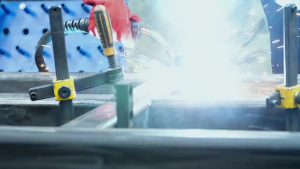 Mann schweißt Metallrohlinge in Werkstatt eines metallverarbeitenden Betriebs — Stockvideo
