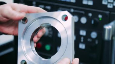 Elinde çelik parça tutan işçi. İşçi kusurları için metal parçası kontrol