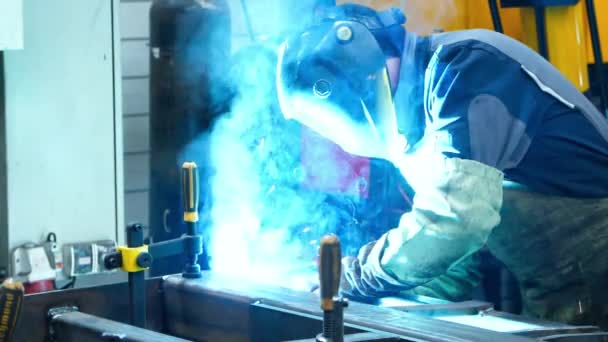 Worker making welding of metal surfaces producing many bright flashes and sparks — Stock Video