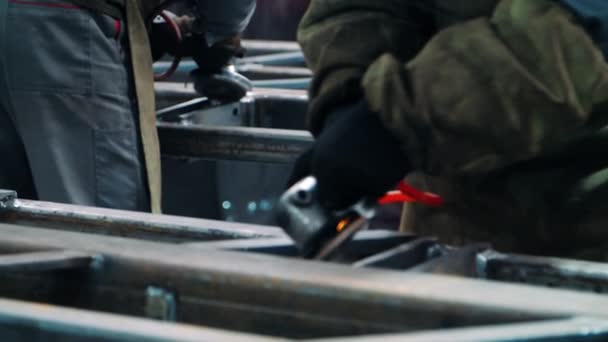 Professionele werknemers polijsten metalen oppervlakken met haakse slijpers in werkplaats — Stockvideo