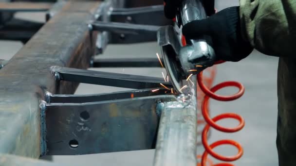 Werknemer glad naden op metalen constructie door Haakse slijper — Stockvideo