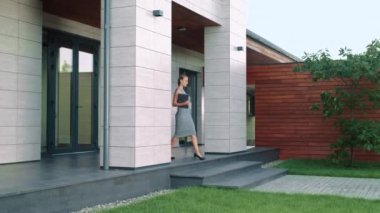 Şık iş kadını dizüstü bilgisayarile ofisten ayrılıyor. Güzellik kadın dışarı gidiyor