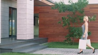 Alışveriş çantasıyla lüks dairelere giren kadın. Eve gelen kadın müşteri