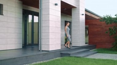 Zarif bir kadın zengin bir eve gidiyor. Otel dışına giden iş kadını.