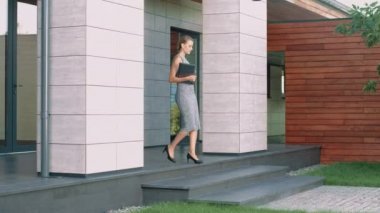 İş kadını dizüstü bilgisayar ile ofis binası terk.