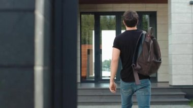 Sırt çantasıyla modern ofise giren sıradan bir adam. Modern adam merdivenlerden çıkıyor