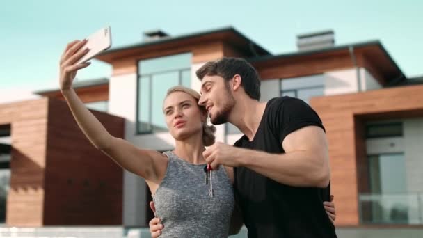 Beautiful couple taking selfie with house keys outside residence. — Stock Footage Beautiful couple taking selfie with house keys outside residence. Video Clip