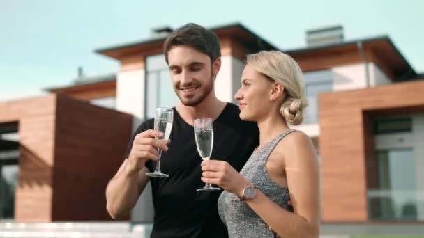 Lovely couple toasting champagne near luxury apartments. — Stock Footage Lovely couple toasting champagne near luxury apartments. Royalty Free Stock Footage