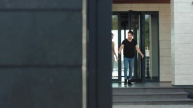 Kendinden emin çift birlikte hi tech binadan dışarı gidiyor.