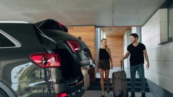 Όμορφη ζευγάρι αποσκευές φόρτωσης στο αυτοκίνητο στο γκαράζ. Χαρούμενες οικογενειακές βαλίτσες. — Αρχείο Βίντεο