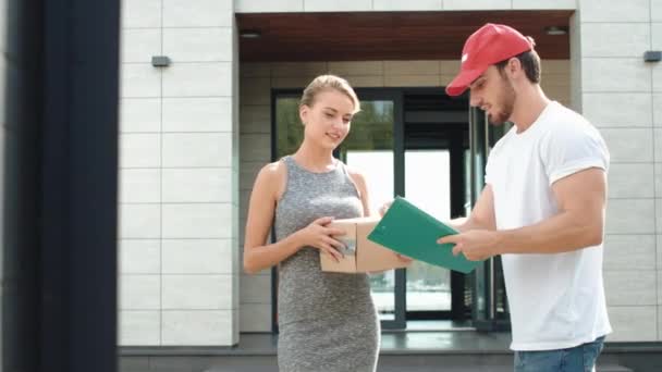 Happy woman meeting delivery man with paper box. Smiling woman receiving parcel — Stock Video