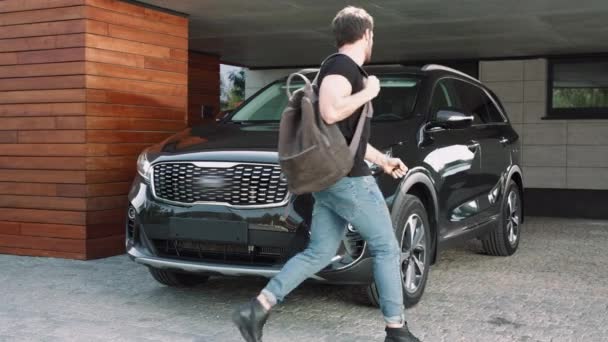 Hombre sexy sentado en coche de lujo en el garaje. Caucásico hombre apertura negro coche — Vídeos de Stock