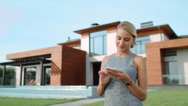 Femme gaie utilisant le téléphone mobile à l'appartement de luxe . — Video