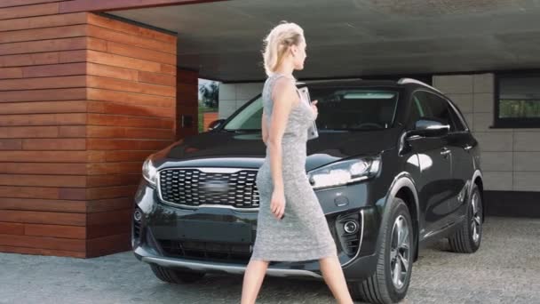 Ділова жінка сидить у багатій машині. Красива жінка, що йде до чорного авто . — стокове відео