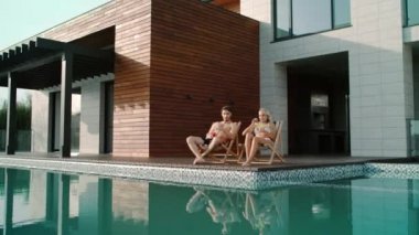 Güzel bir çift dışarıda kokteyl içiyor. Mutlu çift güneşlenmenin tadını çıkarıyor