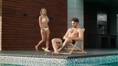 Yakışıklı adam lüks evde havuz yakınında cep telefonu kullanarak.