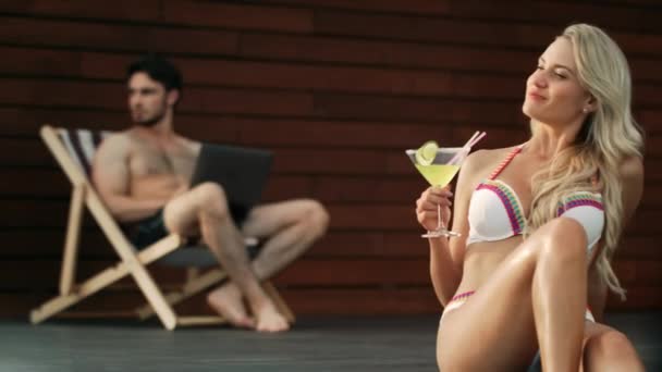 Seksowna kobieta picie koktajlu na basenie w luksusowym domu. — Wideo stockowe